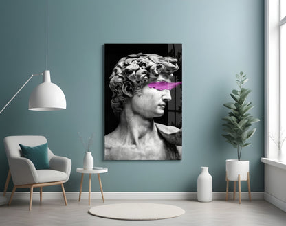 Classical marble bust sculpture with bright magenta neon stripe across eyes, displayed on teal wall in modern interior setting.