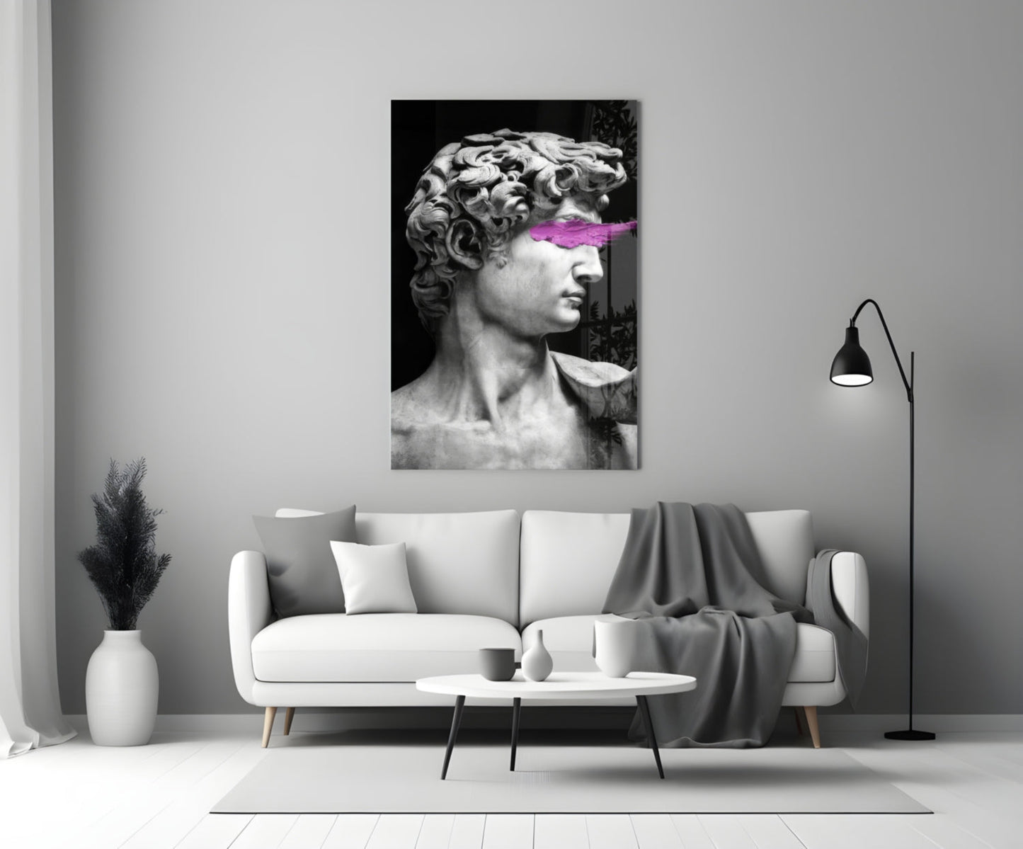 Classical marble bust with neon pink paint stroke across eyes, displayed above white sofa in minimalist interior.
