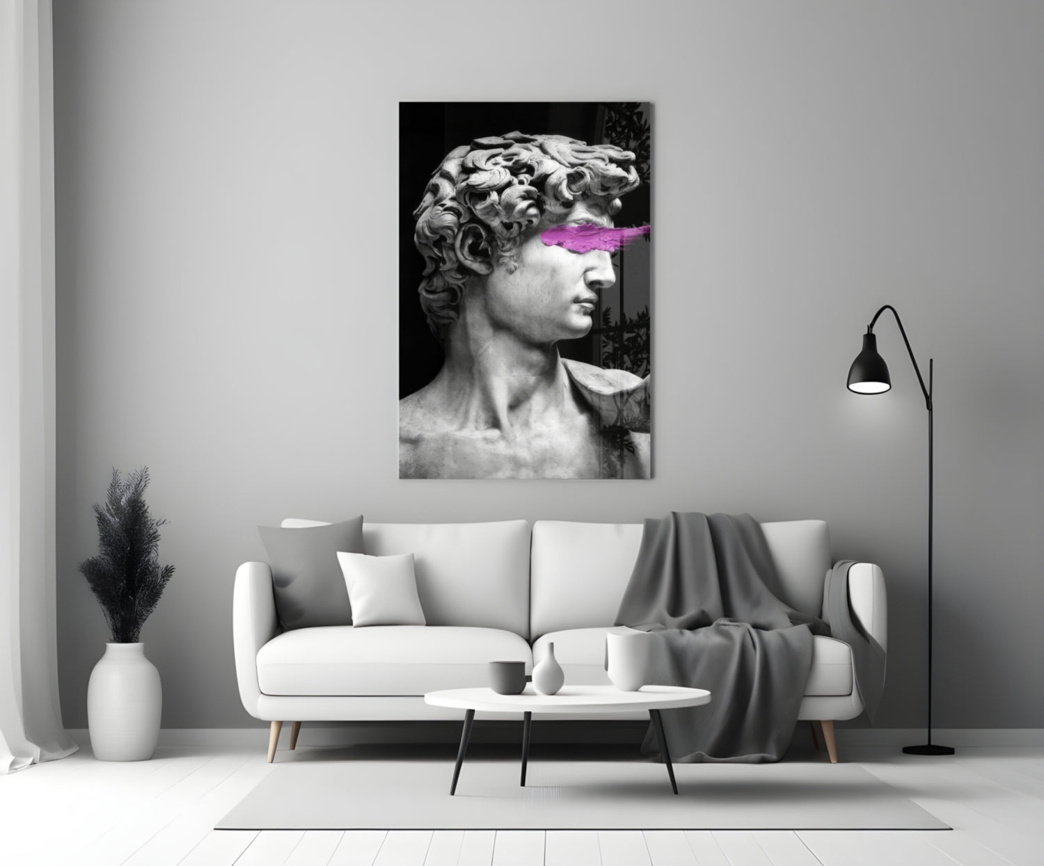 Classical marble bust with neon pink paint stroke across eyes, displayed above white sofa in minimalist interior.