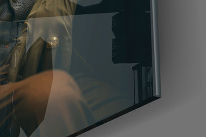 Close-up side view of glass wall art showing a gentleman's silhouette profile with warm golden lighting against dark background.
