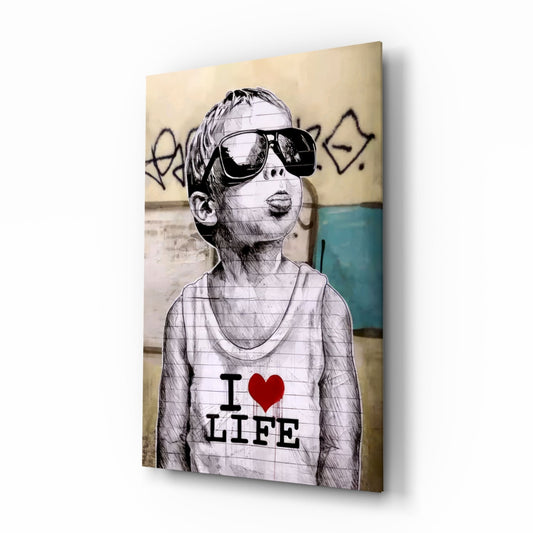 Glass wall art featuring a sketch-style illustration of a child wearing oversized sunglasses and "I ❤ LIFE" shirt against a textured urban background.