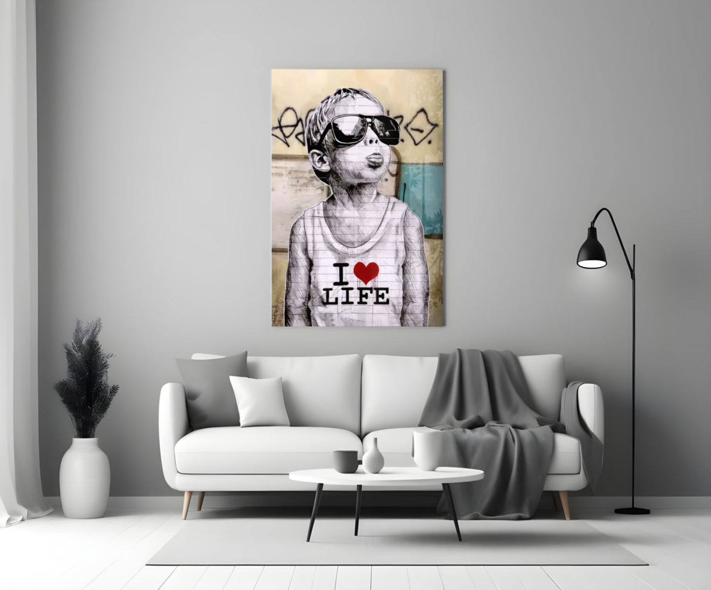 Glass wall art depicting a child wearing sunglasses and "I Love Life" shirt displayed above a white sofa in a modern living room.