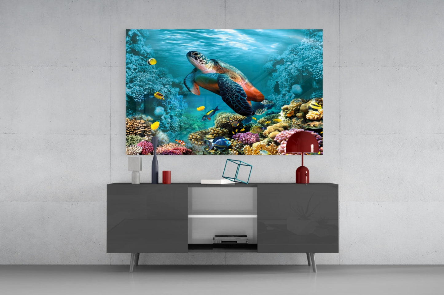 Sea turtle swimming through vibrant coral reef with yellow fish and colorful corals displayed on dark media console in modern interior.