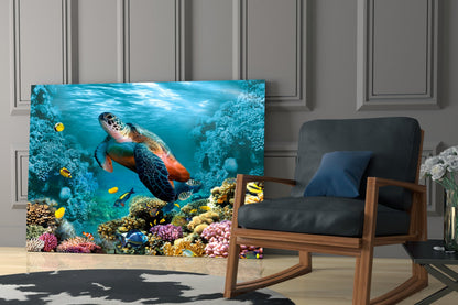 Glass wall art displaying a colorful underwater coral reef scene with sea turtle and tropical fish in a modern living room setting.