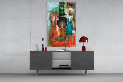 Colorful abstract guitar glass wall art displayed above a dark gray media console with decorative accessories in a modern interior setting.