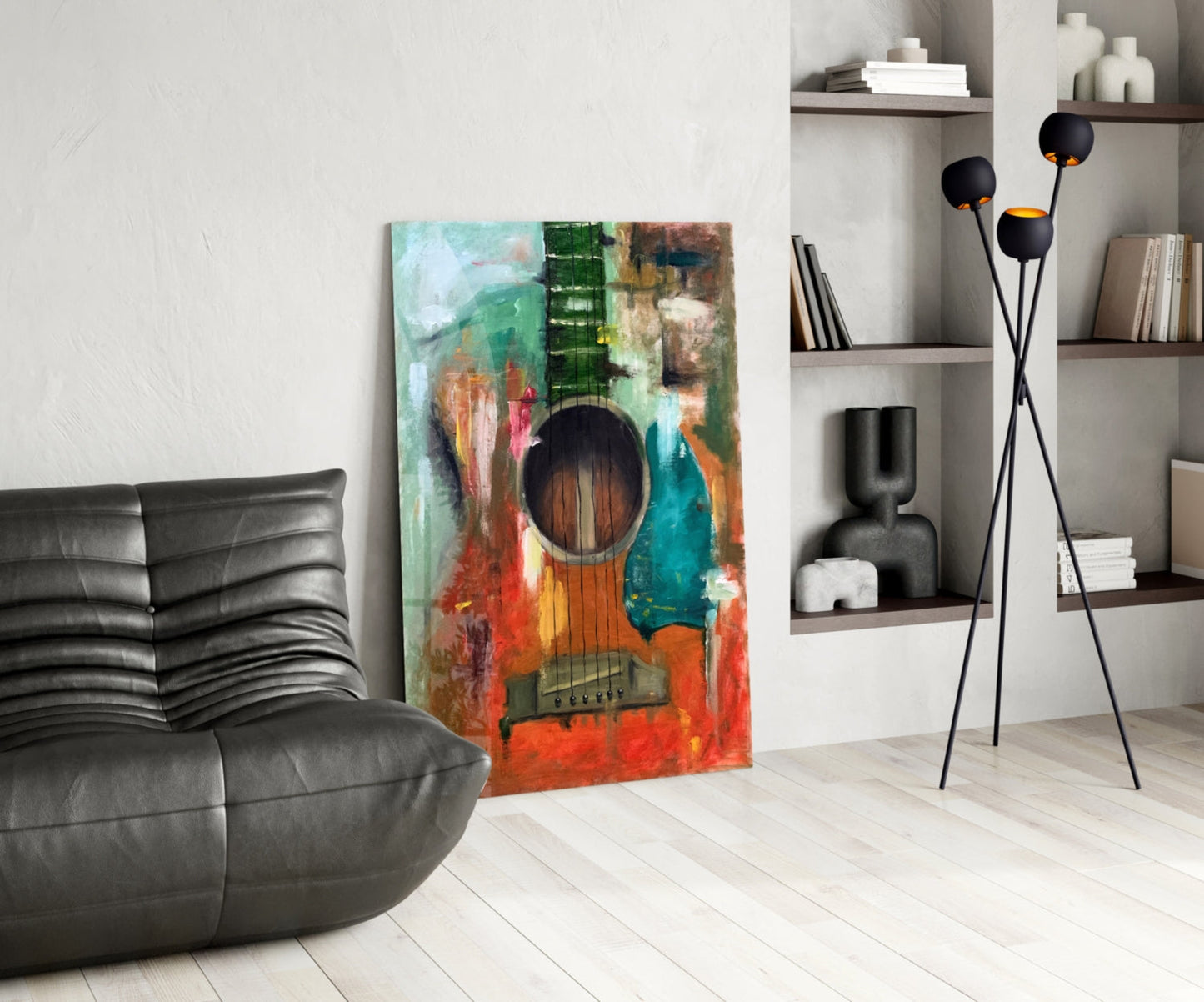 Colorful abstract guitar glass wall art in vibrant reds, greens, and blues leaning against white wall in modern living room setting.