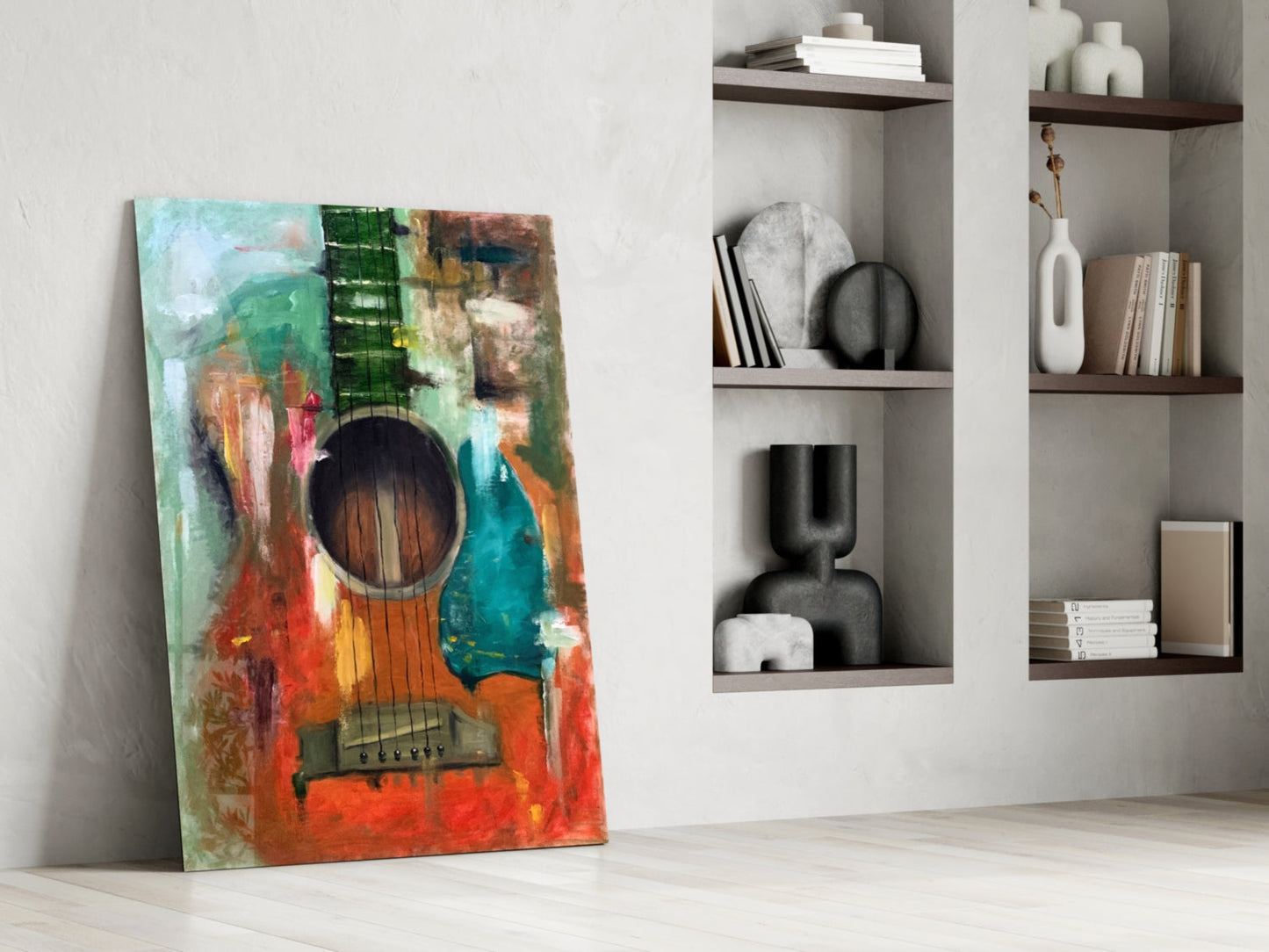 Colorful abstract guitar artwork leaning against white wall beside shelving unit displaying decorative objects and books.