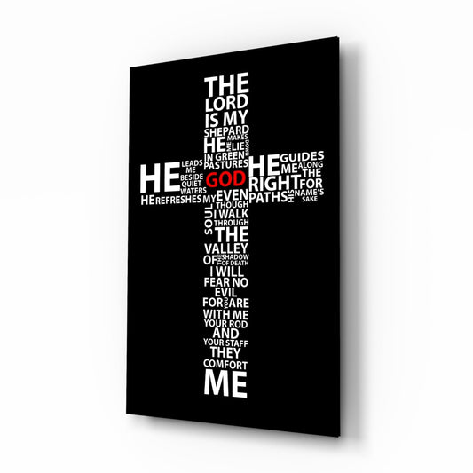 Black glass panel with white and red typography arranged in a cross shape displaying Psalm 23, photographed at a three-quarter angle showing depth and shadow.