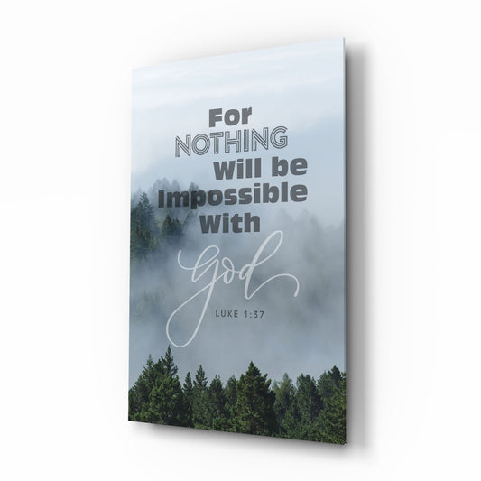 Angled perspective of a glass wall art panel displaying a misty forest landscape with bold text reading "For NOTHING will be impossible with God" and "LUKE 1:37" in script font.