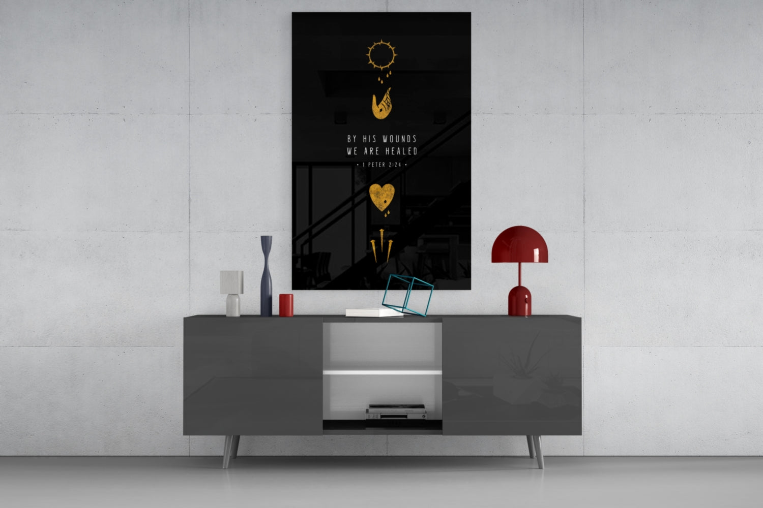 Black glass wall art with gold sun, heart, and arrow symbols above white text reading "By His Wounds We Are Healed - 1 Peter 2:24" displayed on gray media console.