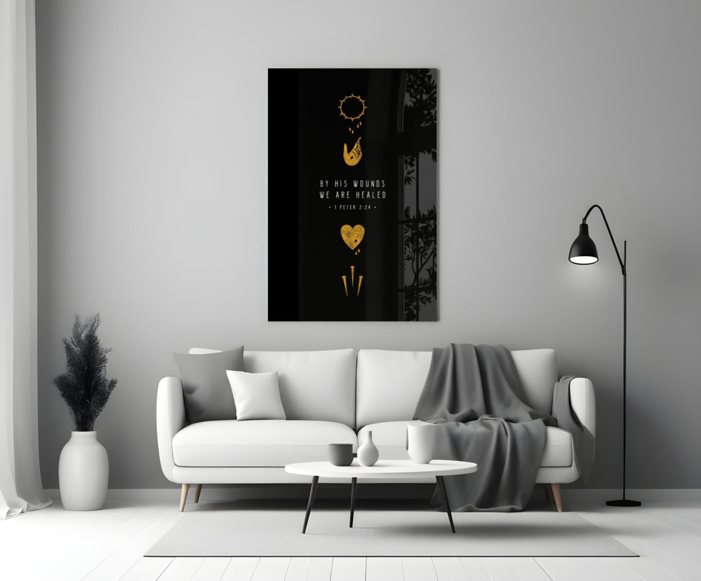 Black glass wall art with gold religious symbols and "By His Wounds We Are Healed" text displayed above white sofa in modern living room.