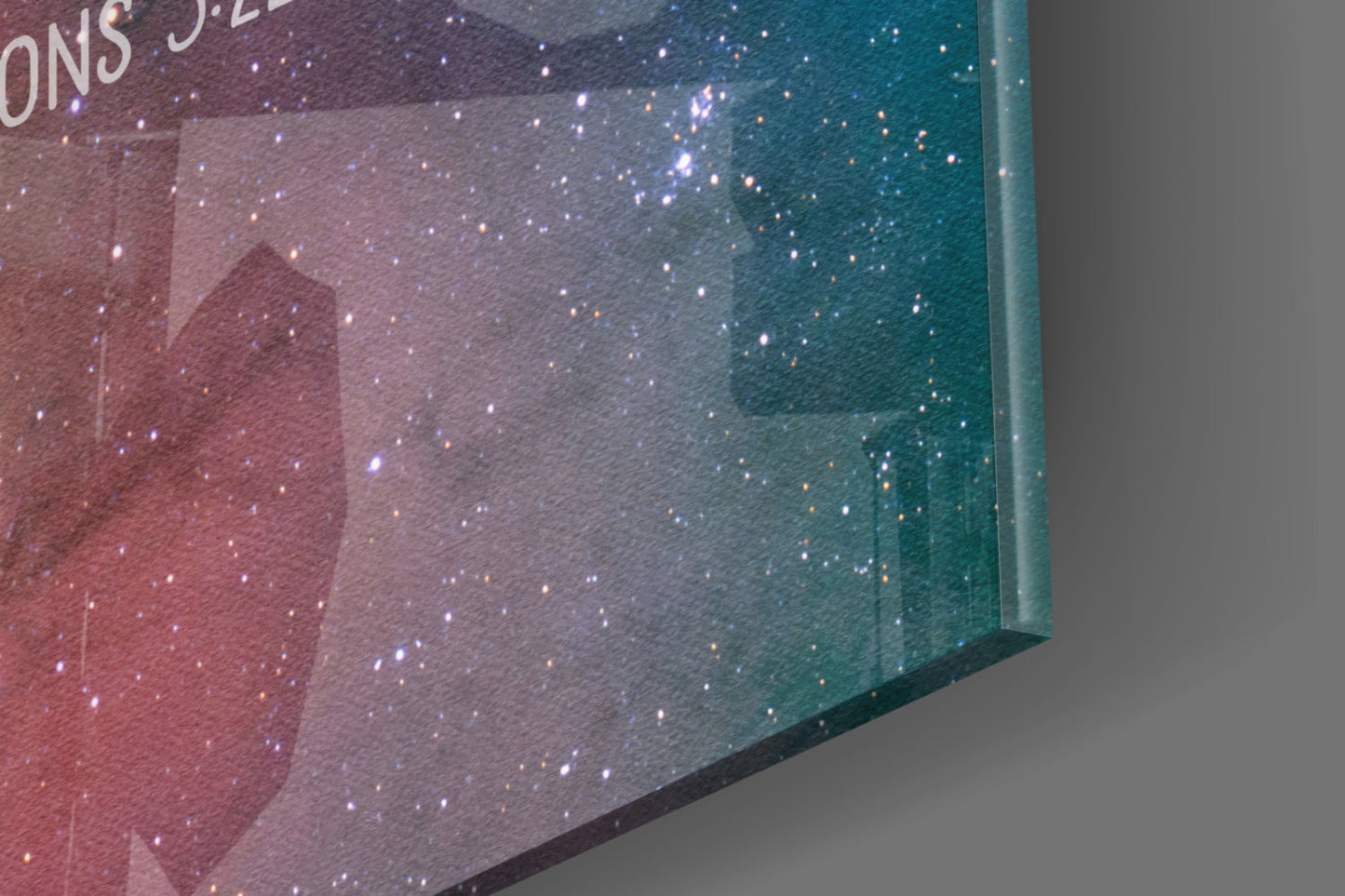 Angled close-up of glass wall art showing gradient from burgundy to teal with white sparkle effects and partial text at top.