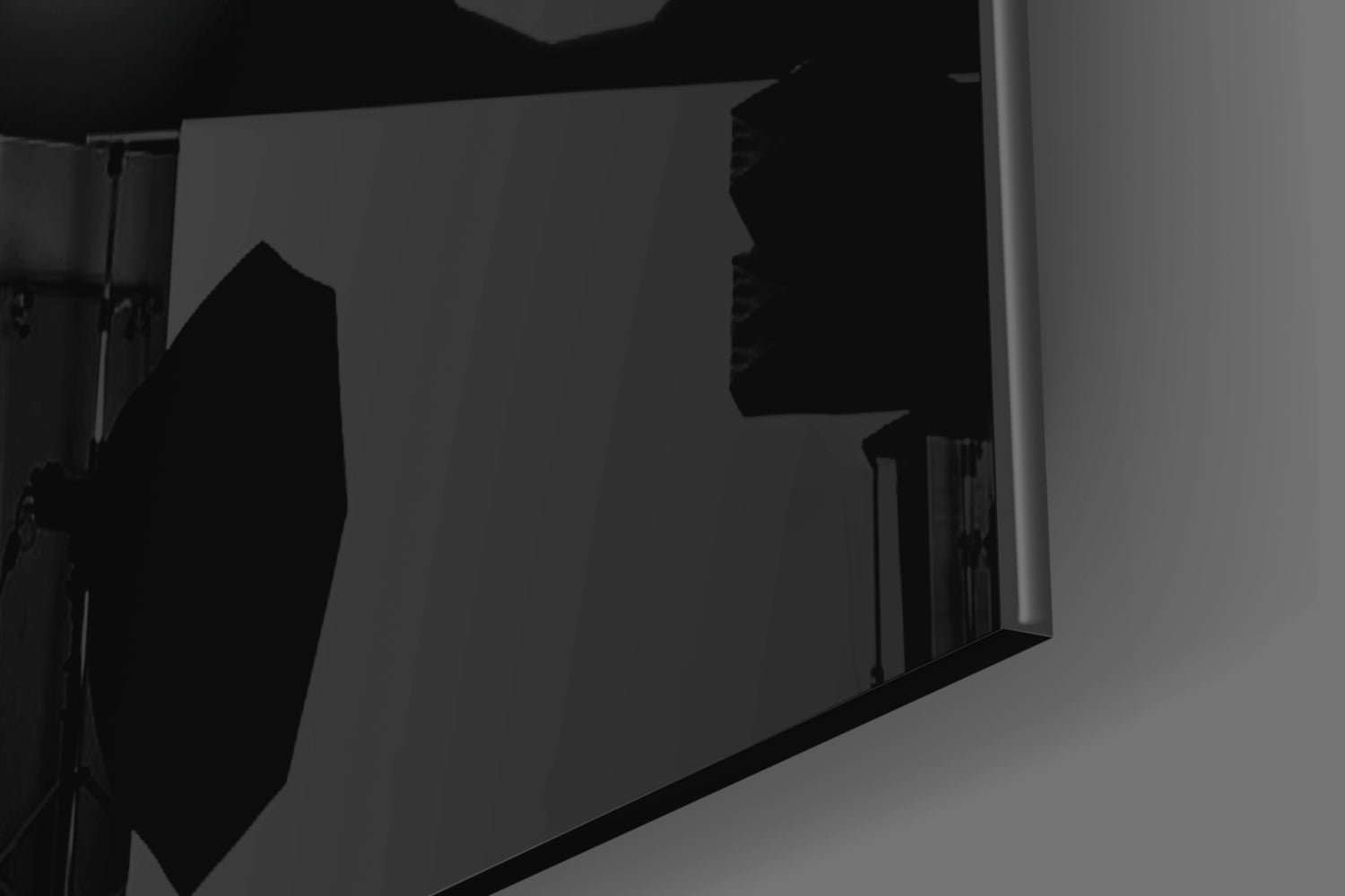 Silhouette view of black glass wall art piece mounted on light gray wall in studio lighting setup.