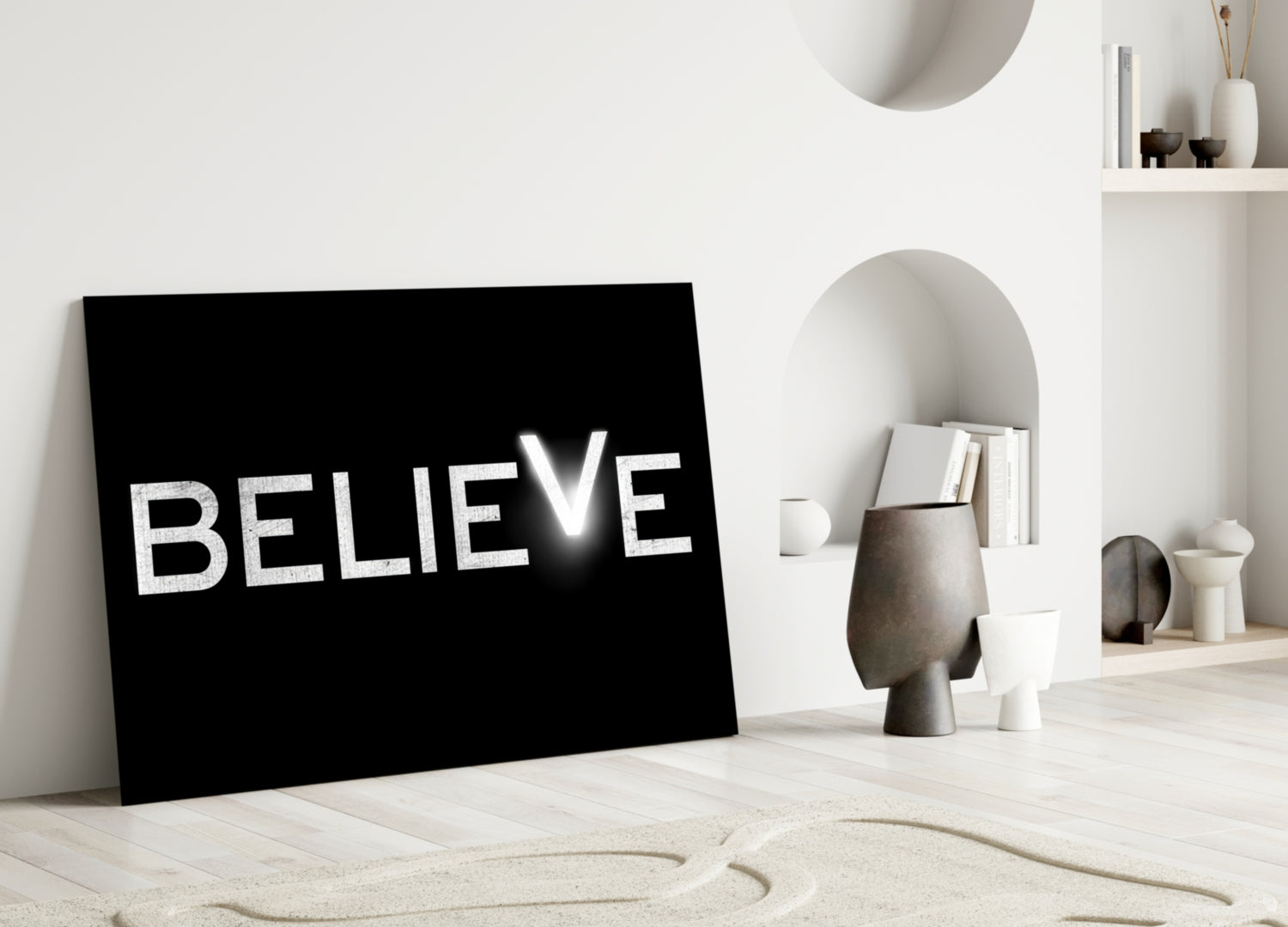 Black glass panel with white "BELIEVE" text leaning against white wall in minimalist room setting.