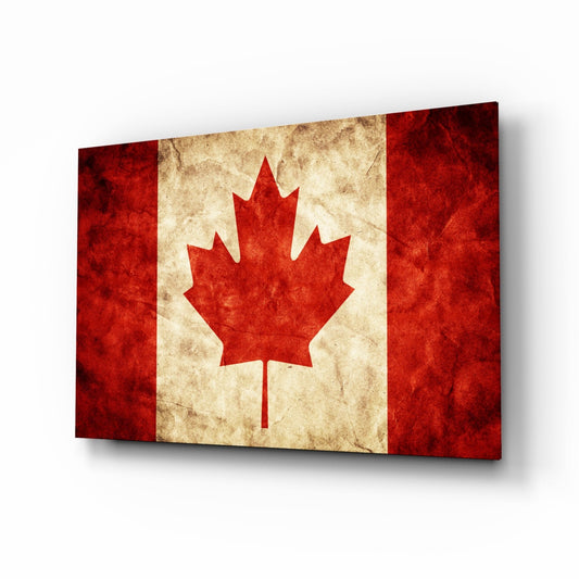 Angled perspective view of vintage Canadian flag glass wall art with distressed red and cream colors and central maple leaf design.