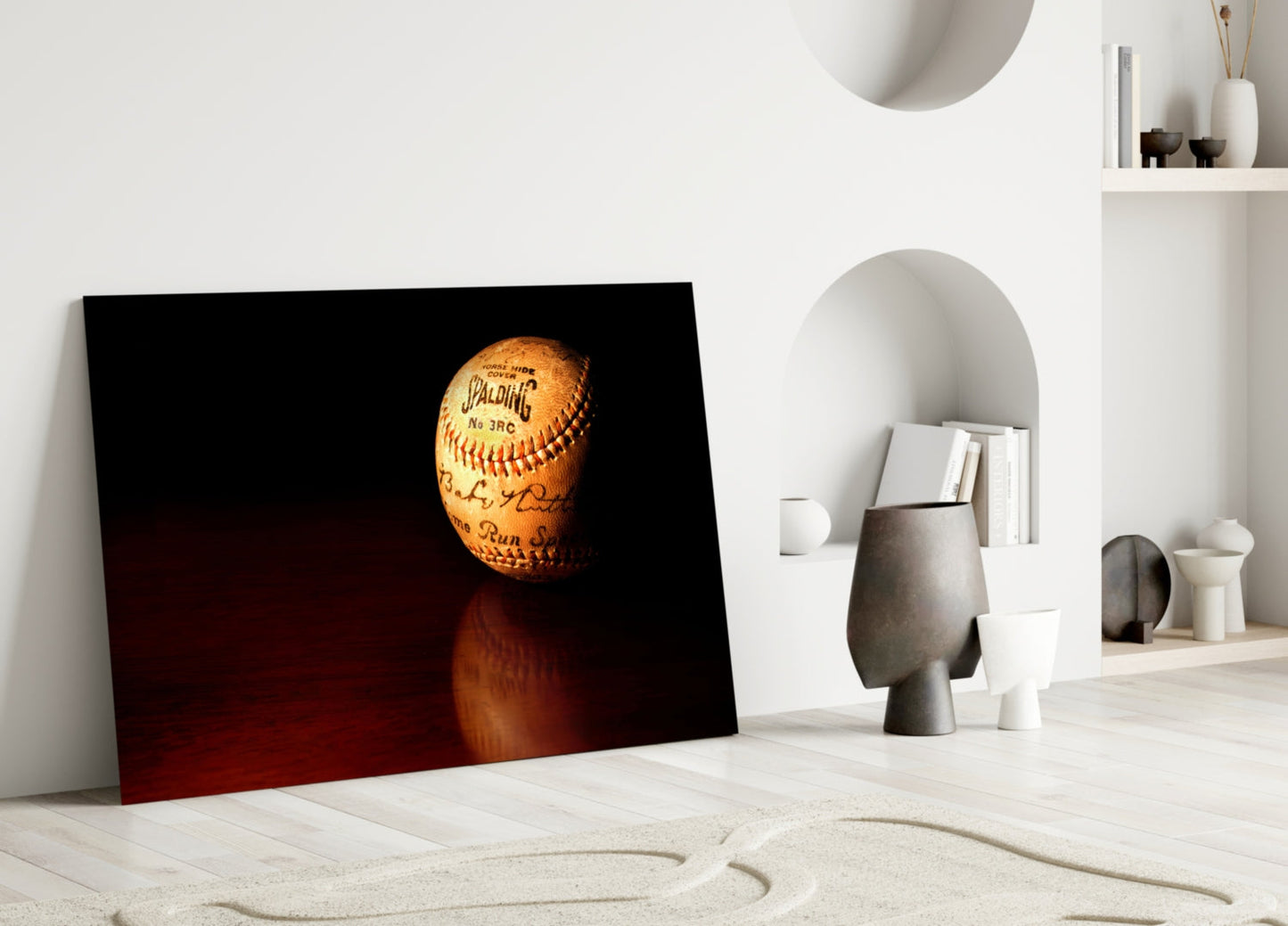 Vintage Spalding baseball with yellow stitching displayed in glass art against dark red gradient background, leaning against white interior wall.