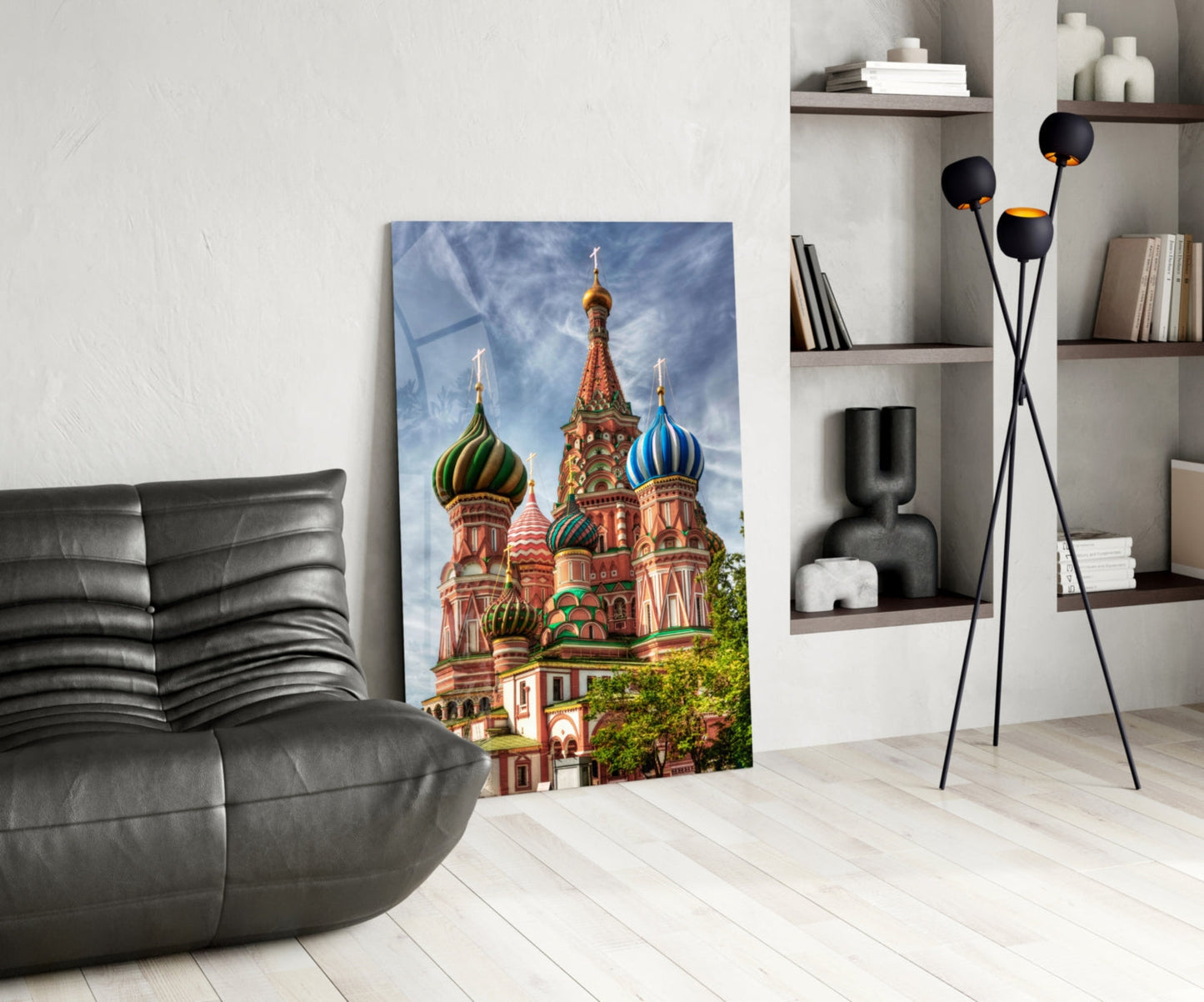 Saint Basil's Cathedral glass art leaning against white wall in modern living room with black chair and shelving.