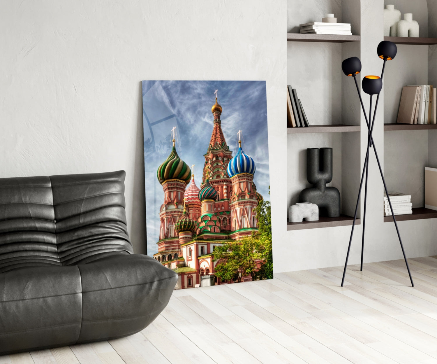 Saint Basil's Cathedral glass art leaning against white wall in modern living room with black chair and shelving.