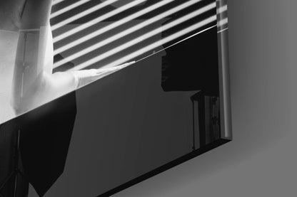 Black and white photograph of an architectural corner showing a louvered vent with strong shadow lines cast on white walls.