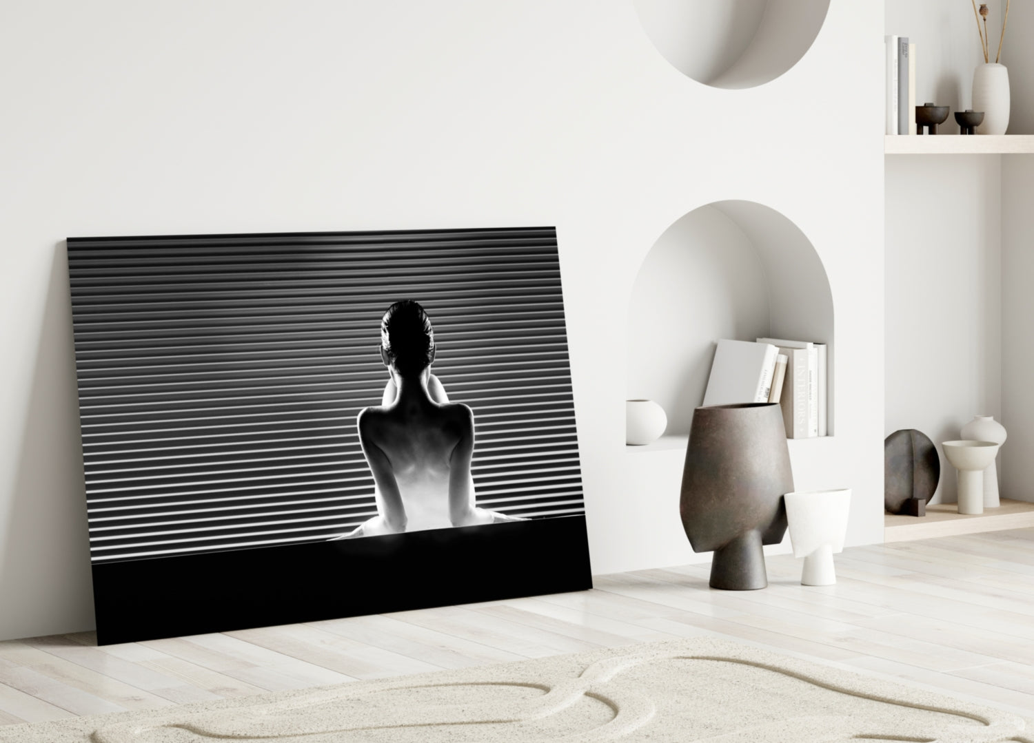 Black and white glass wall art featuring a silhouetted figure against horizontal lines, leaning against white wall in minimalist interior.