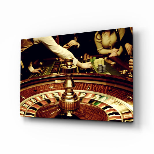 Close-up view of a brass roulette wheel with numbered sections, croupier's hands placing bets in background at a casino table.