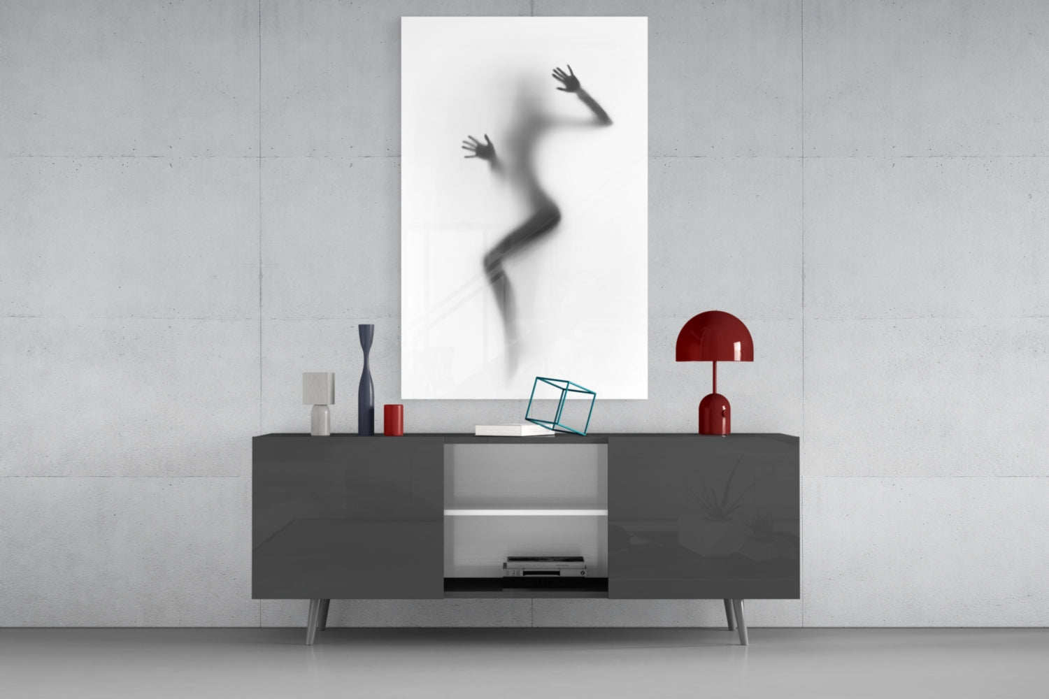 Modern living room display featuring a blurred silhouette of a woman in motion on a white framed glass panel mounted above a dark gray media console with red decorative accessories.