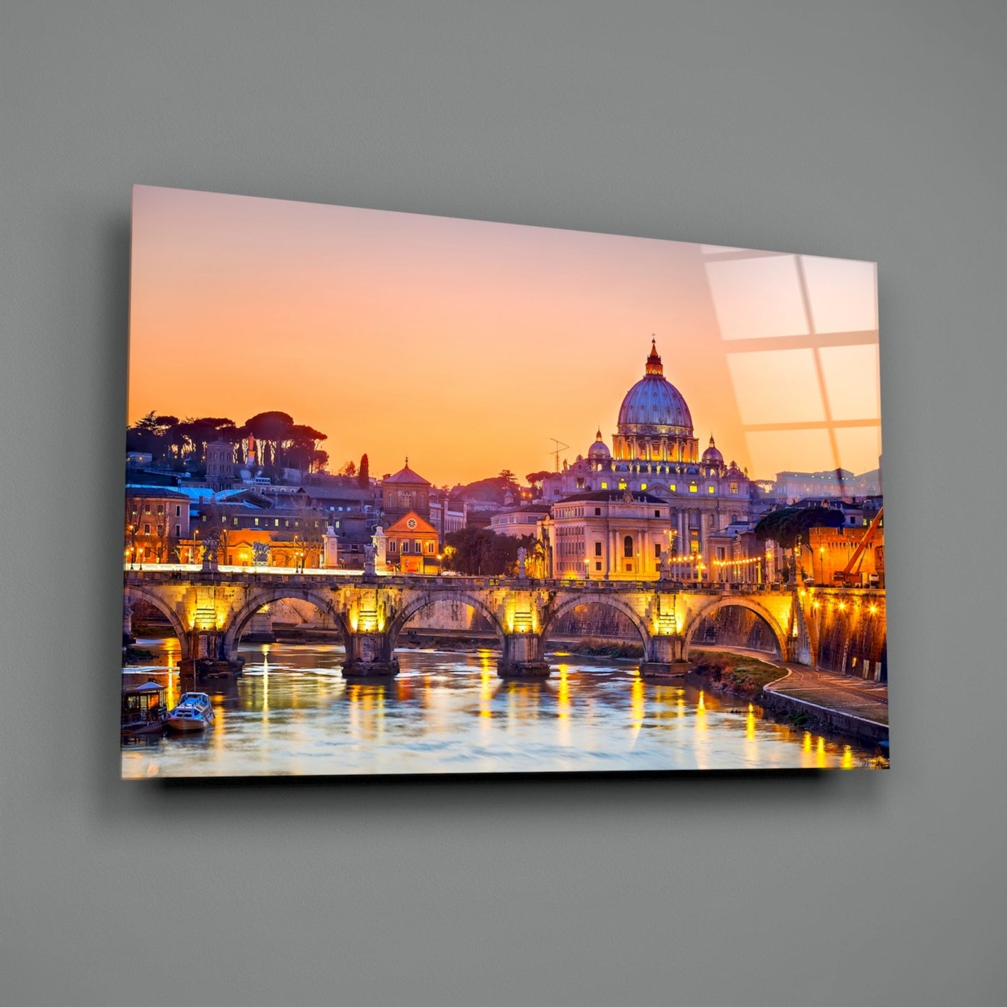Glass wall art displaying Rome's Tiber River at sunset with illuminated bridge and St. Peter's Basilica dome against golden sky.