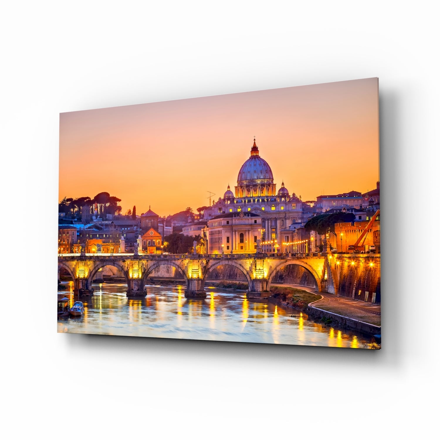 Glass wall art mounted at an angle displaying St. Peter's Basilica illuminated at dusk across the Tiber River with arched bridge in foreground.