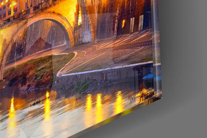 Night-lit street scene with illuminated bridge arch and light trails reflected in glass wall art panel.