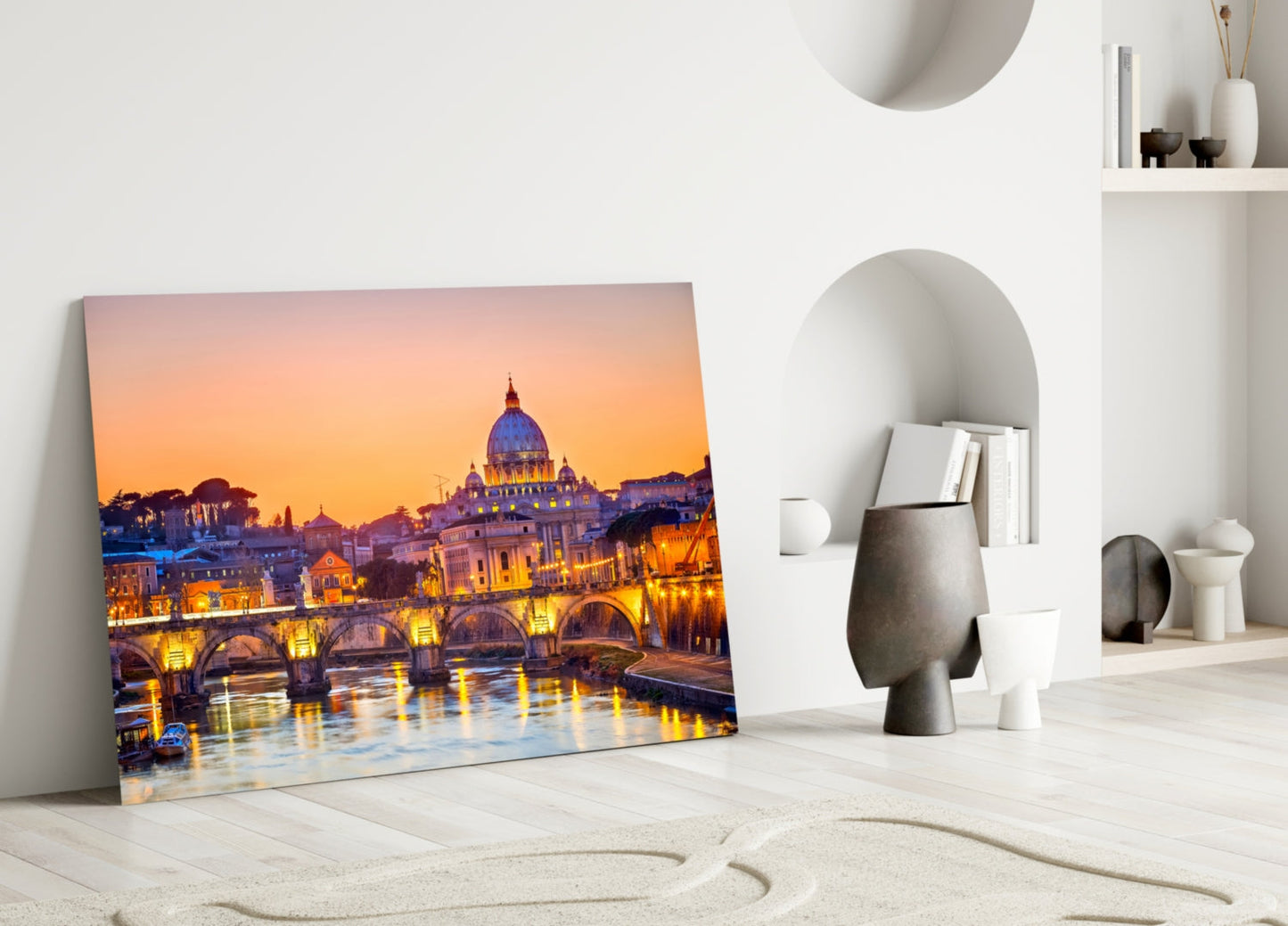 St. Peter's Basilica glass wall art leaning against white wall in minimalist room setting with decorative objects.