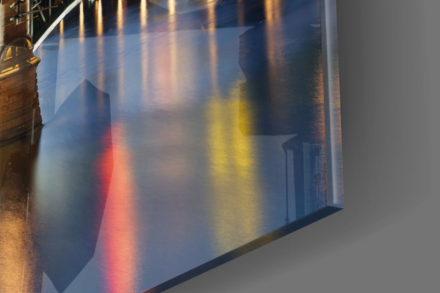 Colorful light refraction through glass panel showing red, yellow, and blue streaks on white wall.