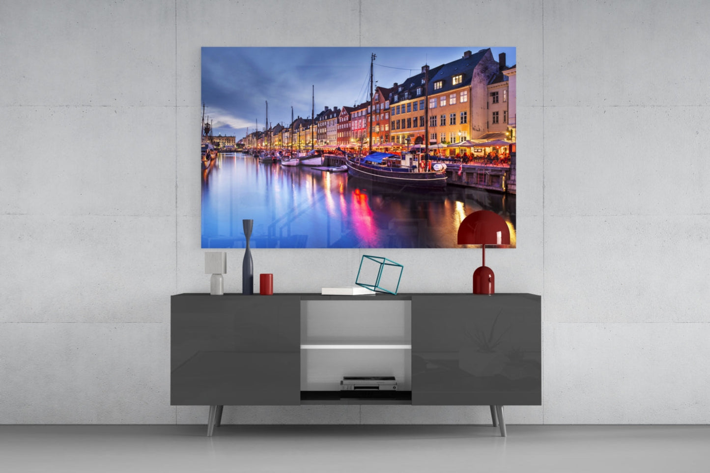 Nyhavn Glass Wall Art mounted above gray media console, displaying illuminated Copenhagen harbor at dusk with colorful buildings and boats reflected in water.