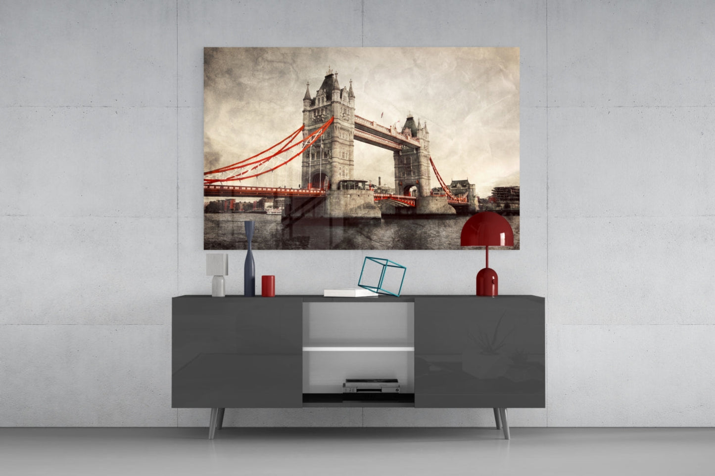 Tower Bridge glass wall art with red cables displayed above gray media console in modern interior setting.