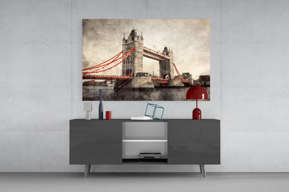 Tower Bridge glass wall art with red cables displayed above gray media console in modern interior setting.