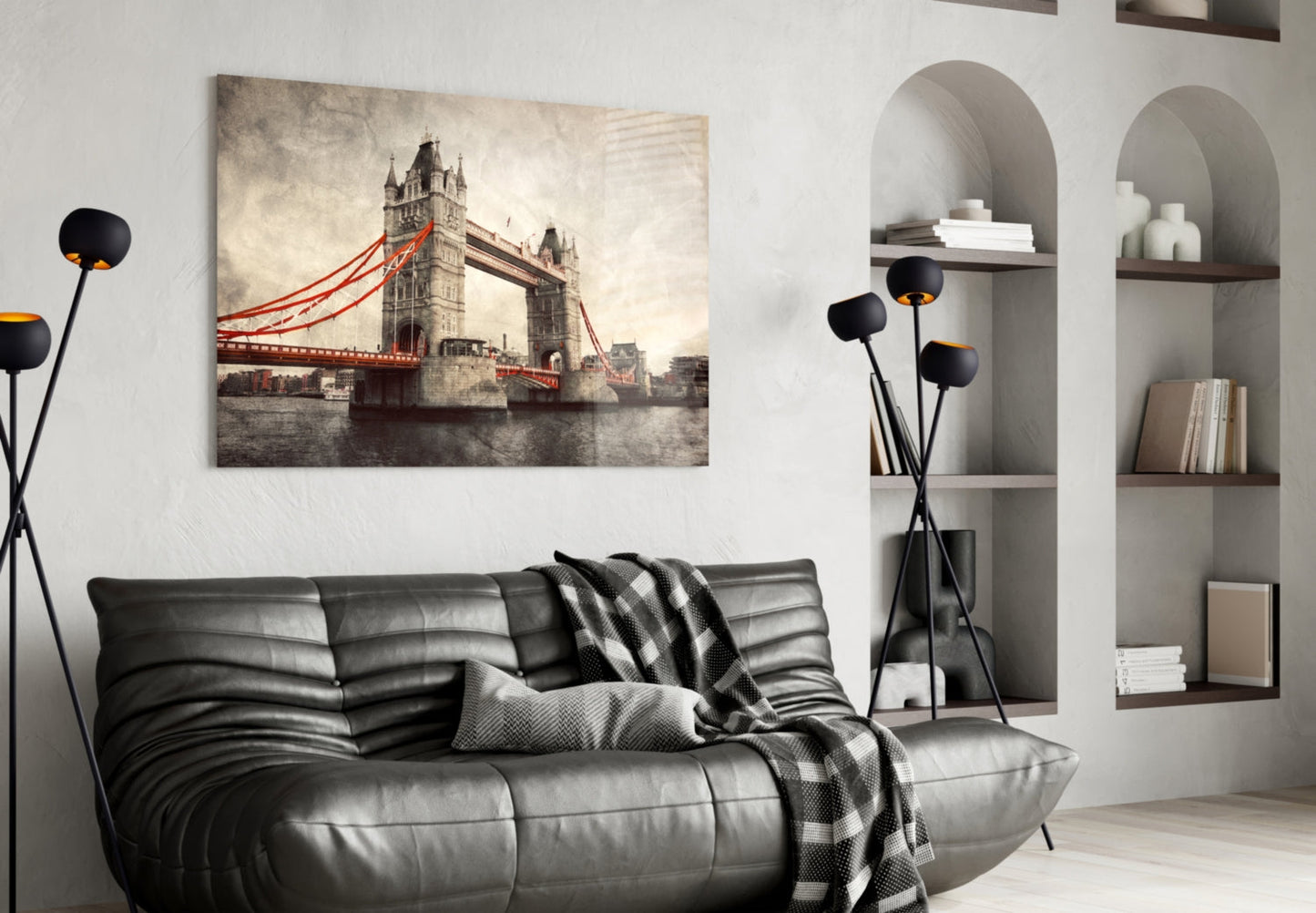 Tower Bridge glass wall art with red cables displayed above black leather sofa in modern living room interior.