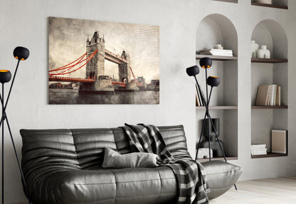 Tower Bridge glass wall art with red cables displayed above black leather sofa in modern living room interior.