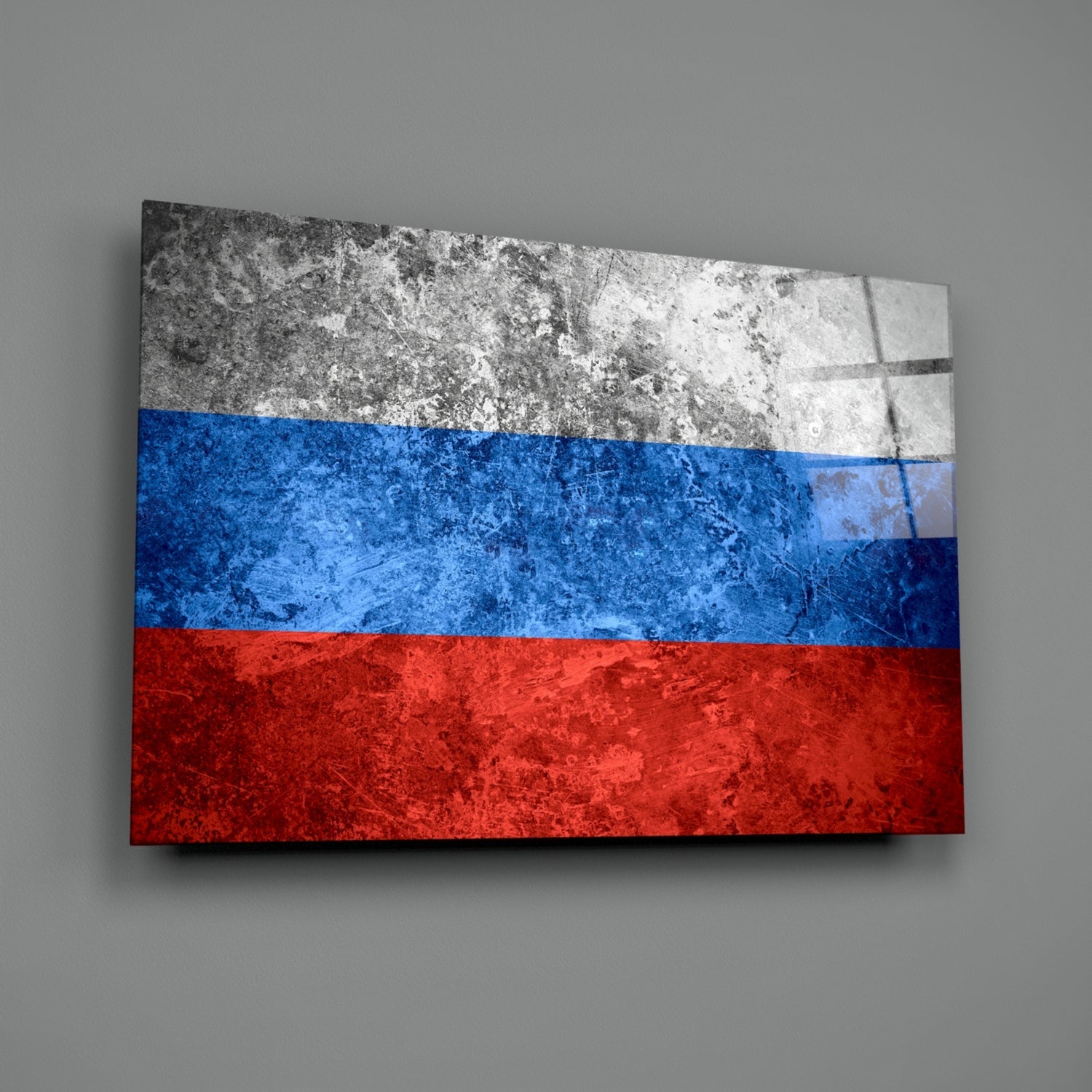 Russian flag glass wall art displayed at an angle against a gray wall, showing white, blue, and red horizontal stripes with weathered texture.
