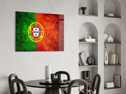 Portuguese flag glass wall art displayed above a round black dining table with gray chairs in a modern interior with white built-in shelving.