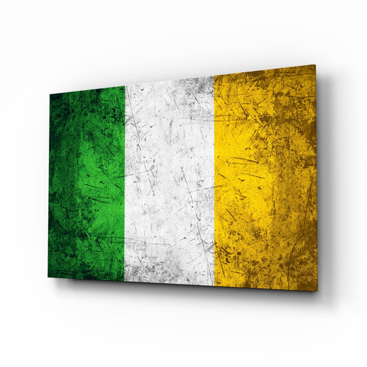 Angled 3D view of glass wall art displaying the Irish flag with green, white, and gold vertical stripes featuring scratched metal texture effects.