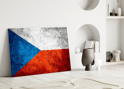 Czech flag glass wall art leaning against white wall in minimalist interior with decorative objects.