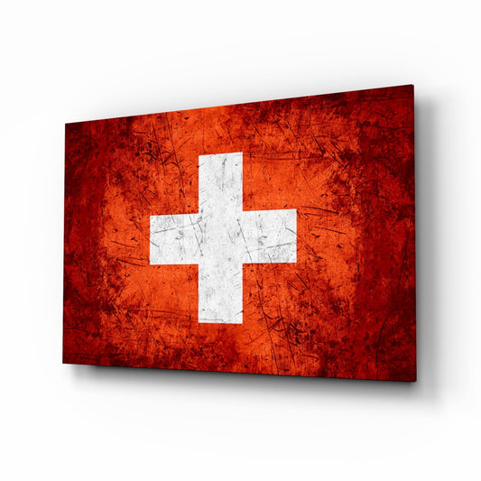 Angled perspective view of a red and white Swiss cross flag glass panel with weathered texture and scratch marks throughout.