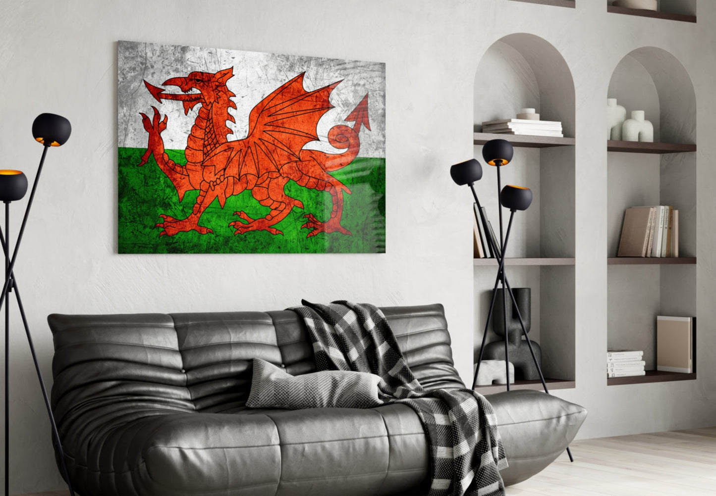 Welsh flag glass wall art displaying red dragon on white and green background, hung above black leather sofa in modern living room.