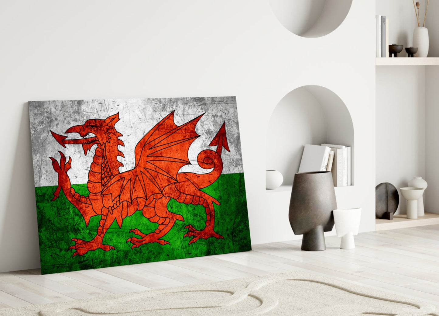 Welsh flag glass wall art leaning against white wall in minimalist interior, displaying red dragon on white and green background.