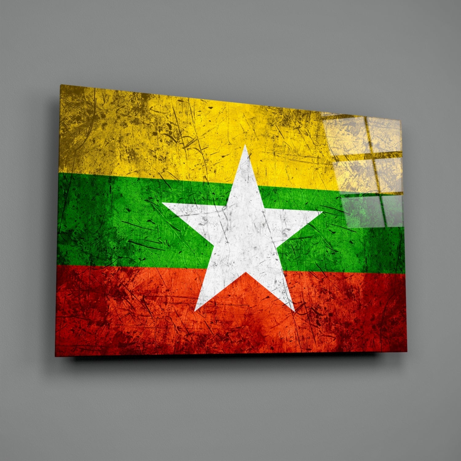 Distressed Myanmar flag with yellow, green, and red horizontal stripes and white star on glass wall art panel against gray background.