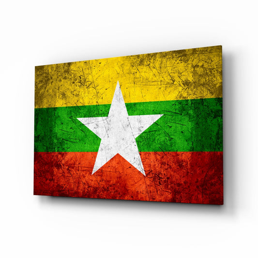 Angled view of Myanmar flag glass wall art displaying yellow, green, and red horizontal stripes with white star, mounted on white background.