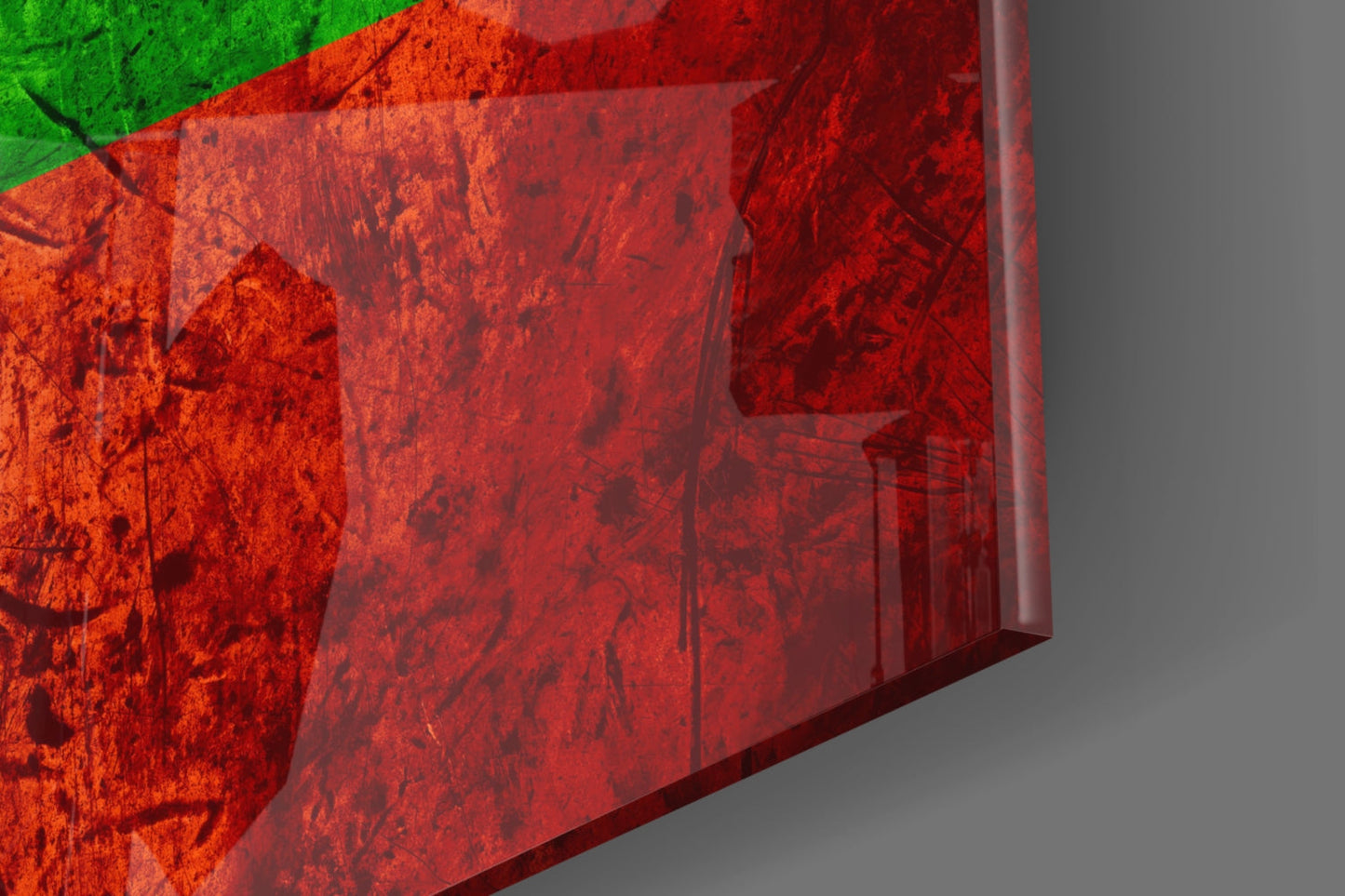 Close-up angled view of translucent red glass panel with green stripe, showing textured surface and layered depth against gray background.
