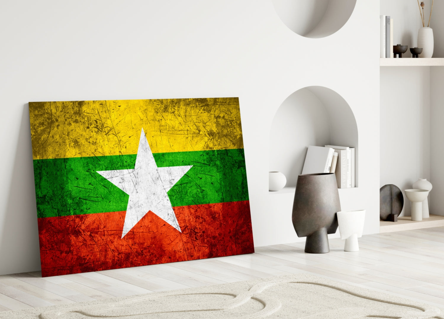 Myanmar flag glass wall art leaning against white wall in minimalist room with decorative objects.