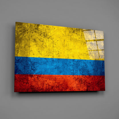 Colombian flag glass wall art displayed at an angle, showing yellow, blue, and red horizontal stripes with a weathered, textured surface.