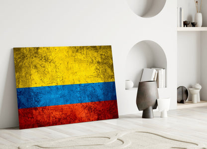 Colombian flag glass art leaning against white wall in minimalist room with decorative objects and shelving.