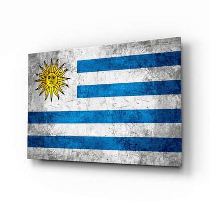 Uruguayan flag glass wall art displayed at an angle, showing blue and white horizontal stripes with a yellow sun symbol, against a white background.